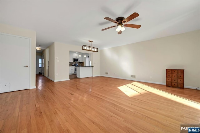 unfurnished living room featuring baseboards, light wood-style flooring, visible vents, and a ceiling fan