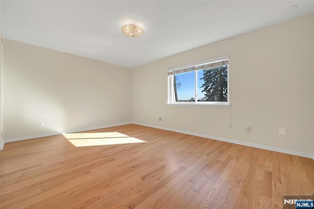 spare room featuring light wood finished floors and baseboards