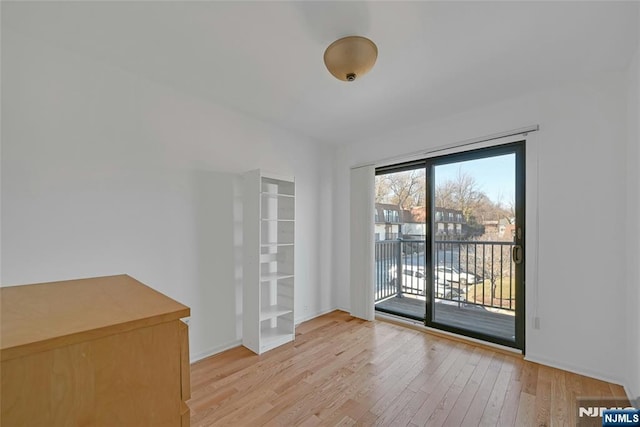 doorway with light wood-style flooring and baseboards