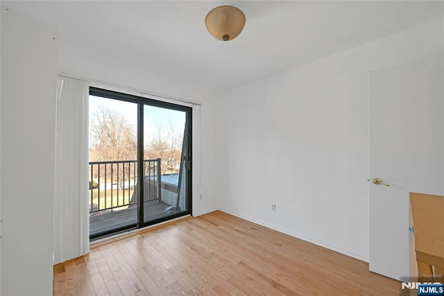 unfurnished room with light wood-type flooring and baseboards