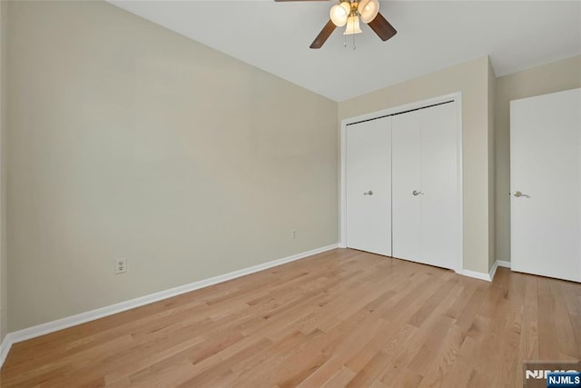 unfurnished bedroom with a ceiling fan, a closet, light wood-style flooring, and baseboards