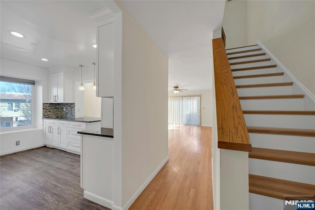 kitchen featuring light wood-style floors, dark countertops, white cabinetry, and decorative backsplash