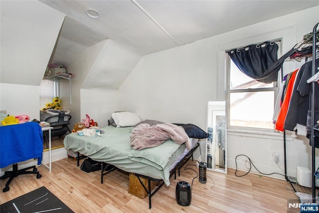 bedroom featuring hardwood / wood-style flooring and lofted ceiling