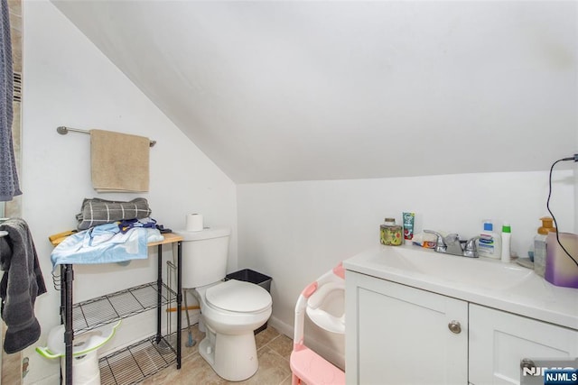 bathroom featuring vanity, toilet, tile patterned flooring, and vaulted ceiling