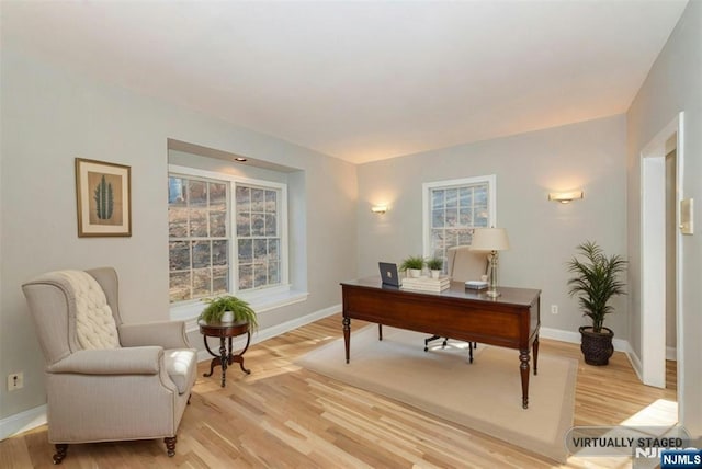 home office with light hardwood / wood-style flooring