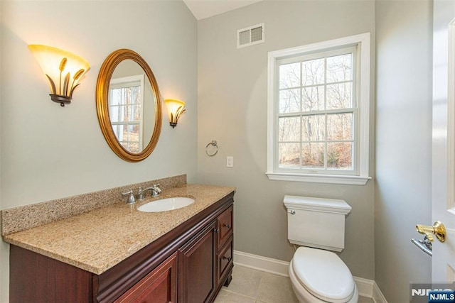 bathroom featuring toilet, a wealth of natural light, tile patterned floors, and vanity