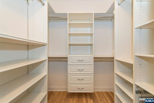 walk in closet with light hardwood / wood-style floors