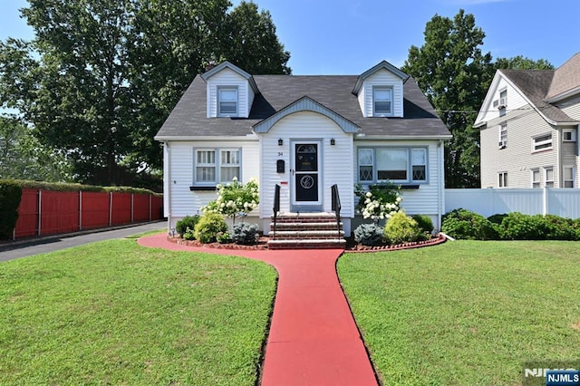 cape cod-style house featuring a front yard and fence