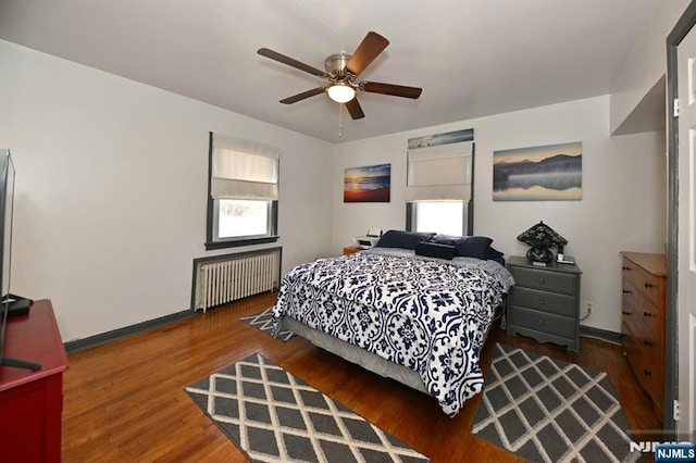 bedroom with radiator, ceiling fan, baseboards, and wood finished floors