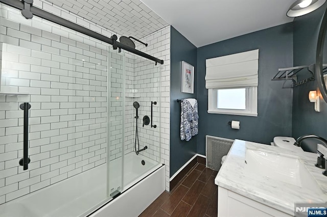 full bathroom featuring visible vents, wood tiled floor, enclosed tub / shower combo, vanity, and baseboards