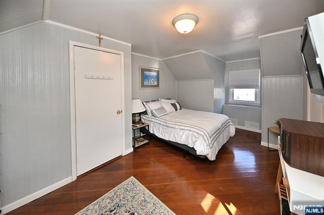 bedroom with lofted ceiling, wood finished floors, and visible vents