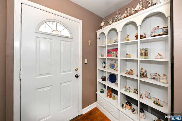 doorway to outside with dark wood-style floors and baseboards