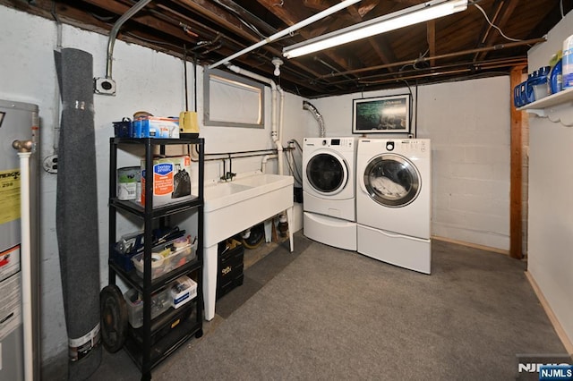 laundry room featuring laundry area, water heater, and washer and dryer