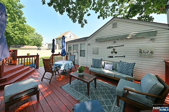 wooden terrace with an outdoor hangout area and fence