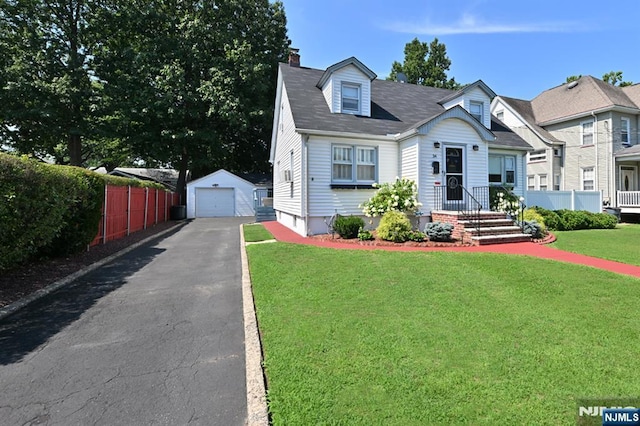 view of front of home featuring aphalt driveway, fence, a garage, an outdoor structure, and a front lawn