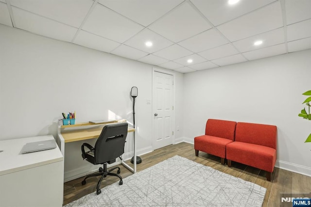 office space featuring dark wood-type flooring and a drop ceiling