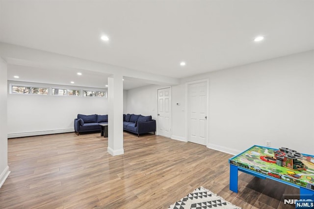 recreation room with light hardwood / wood-style flooring and a baseboard radiator