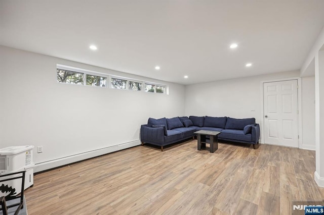 living room featuring baseboard heating and light hardwood / wood-style flooring