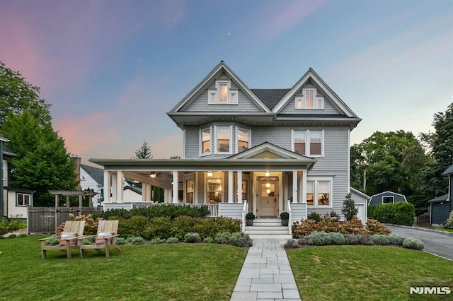 view of front of home with covered porch and a front lawn