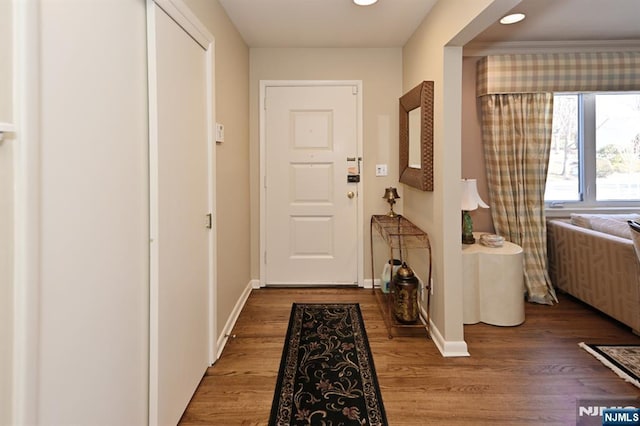 doorway with wood finished floors and baseboards