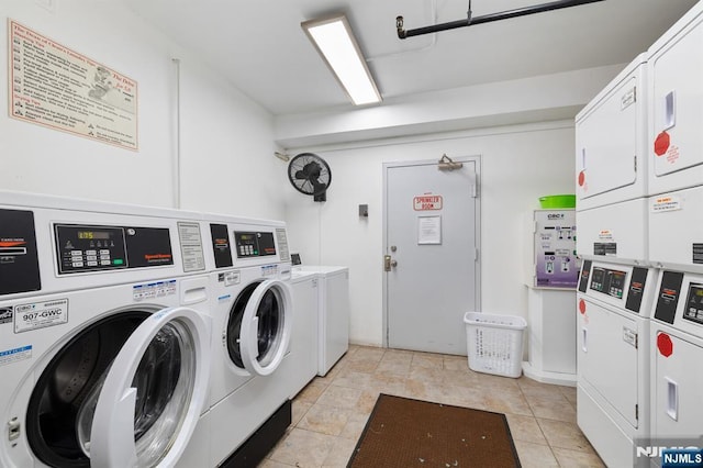 laundry room featuring independent washer and dryer, light tile patterned flooring, and stacked washer and clothes dryer