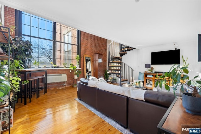 living room featuring hardwood / wood-style floors and brick wall