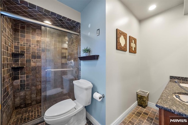 bathroom featuring toilet, baseboards, tiled shower, and vanity