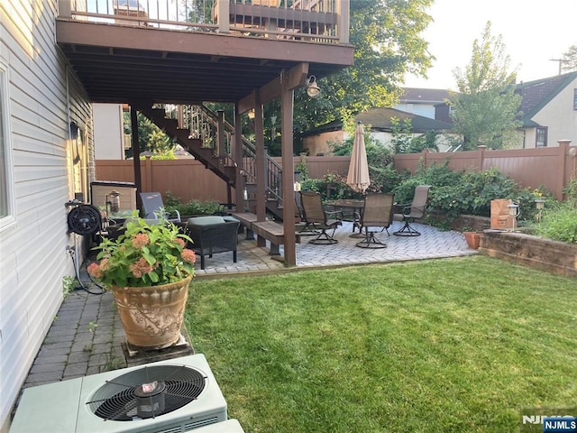 view of yard featuring central AC, a deck, and a patio area