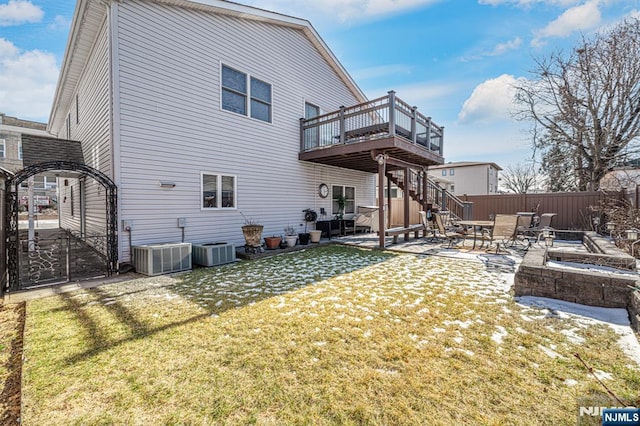 rear view of property featuring a yard, a patio, a deck, and central AC