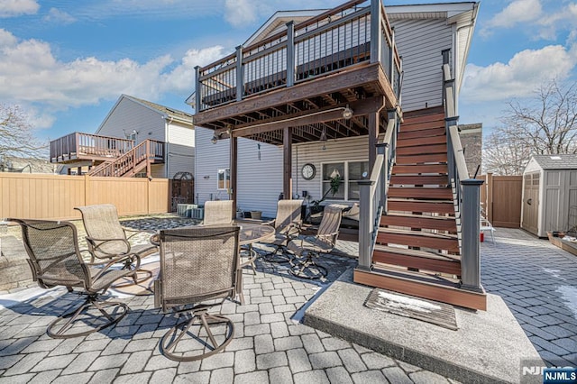 view of patio featuring a deck and a storage unit