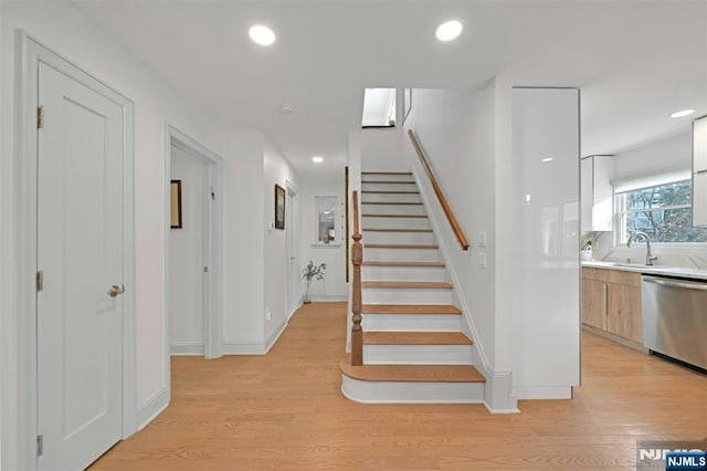 stairway with recessed lighting, baseboards, and wood finished floors