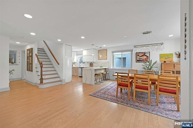 dining room featuring light wood-type flooring, stairway, and recessed lighting