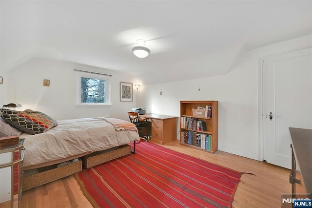 bedroom featuring lofted ceiling and light wood finished floors