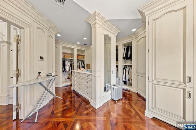 spacious closet featuring ornate columns and dark parquet floors