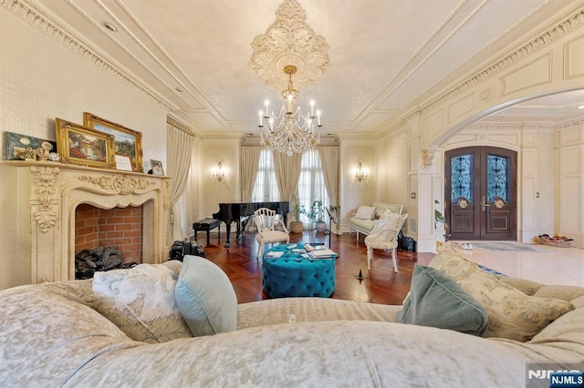 interior space featuring french doors, crown molding, and an inviting chandelier