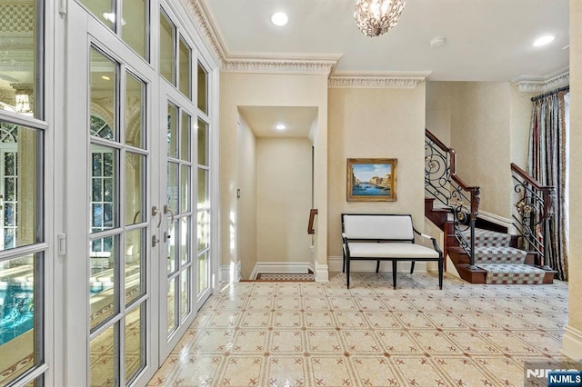 interior space with french doors, crown molding, and an inviting chandelier