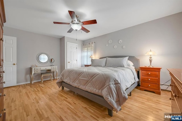 bedroom featuring light wood-style floors, a baseboard radiator, baseboards, and a ceiling fan