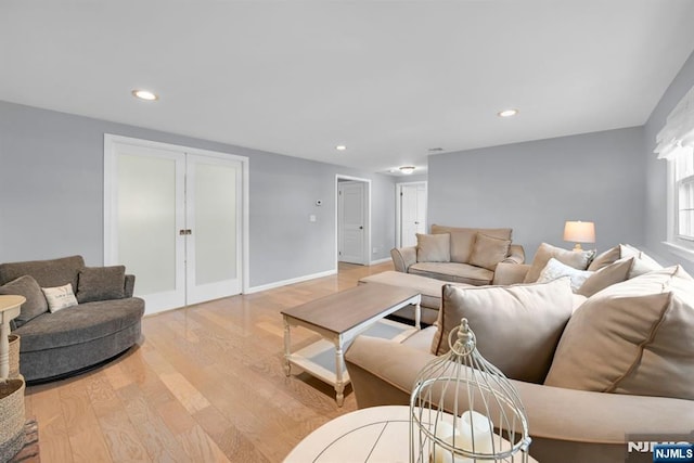 living area with baseboards, wood finished floors, and recessed lighting