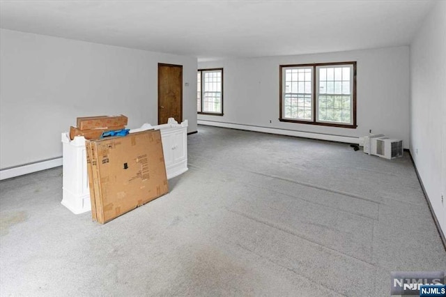 carpeted spare room featuring a baseboard heating unit and a wall mounted air conditioner