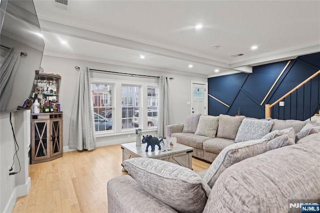 living room with crown molding, light hardwood / wood-style floors, and indoor bar