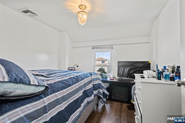 bedroom featuring dark hardwood / wood-style flooring and vaulted ceiling