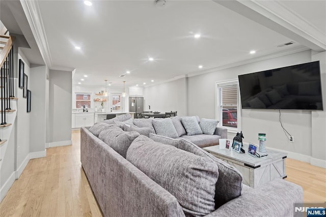 living room featuring light hardwood / wood-style flooring and crown molding