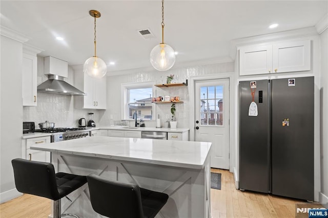 kitchen with white cabinetry, pendant lighting, light stone counters, and appliances with stainless steel finishes