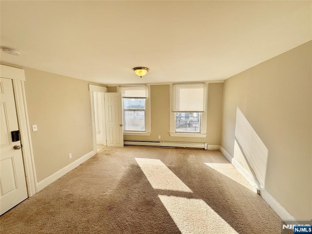 empty room with a baseboard heating unit and light colored carpet