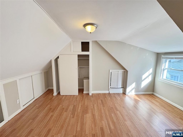 bonus room featuring light hardwood / wood-style floors and vaulted ceiling