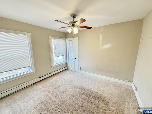 spare room featuring baseboard heating, ceiling fan, and light colored carpet