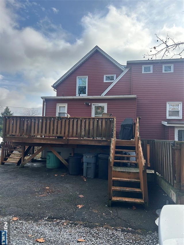 rear view of property with stairway and a wooden deck