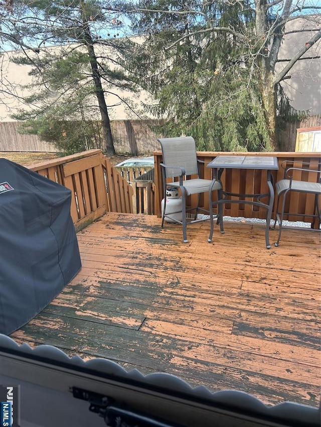 wooden terrace with grilling area and fence