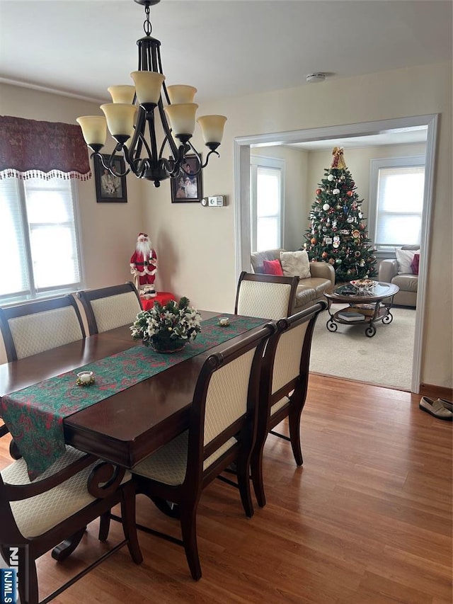 dining space with an inviting chandelier and wood finished floors