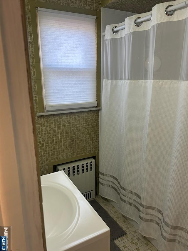 bathroom with radiator heating unit and tile walls